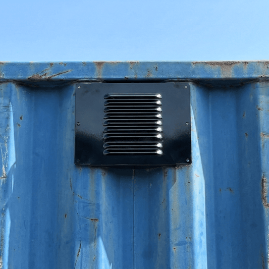 Powered wall vent mounted on the side of a shipping container