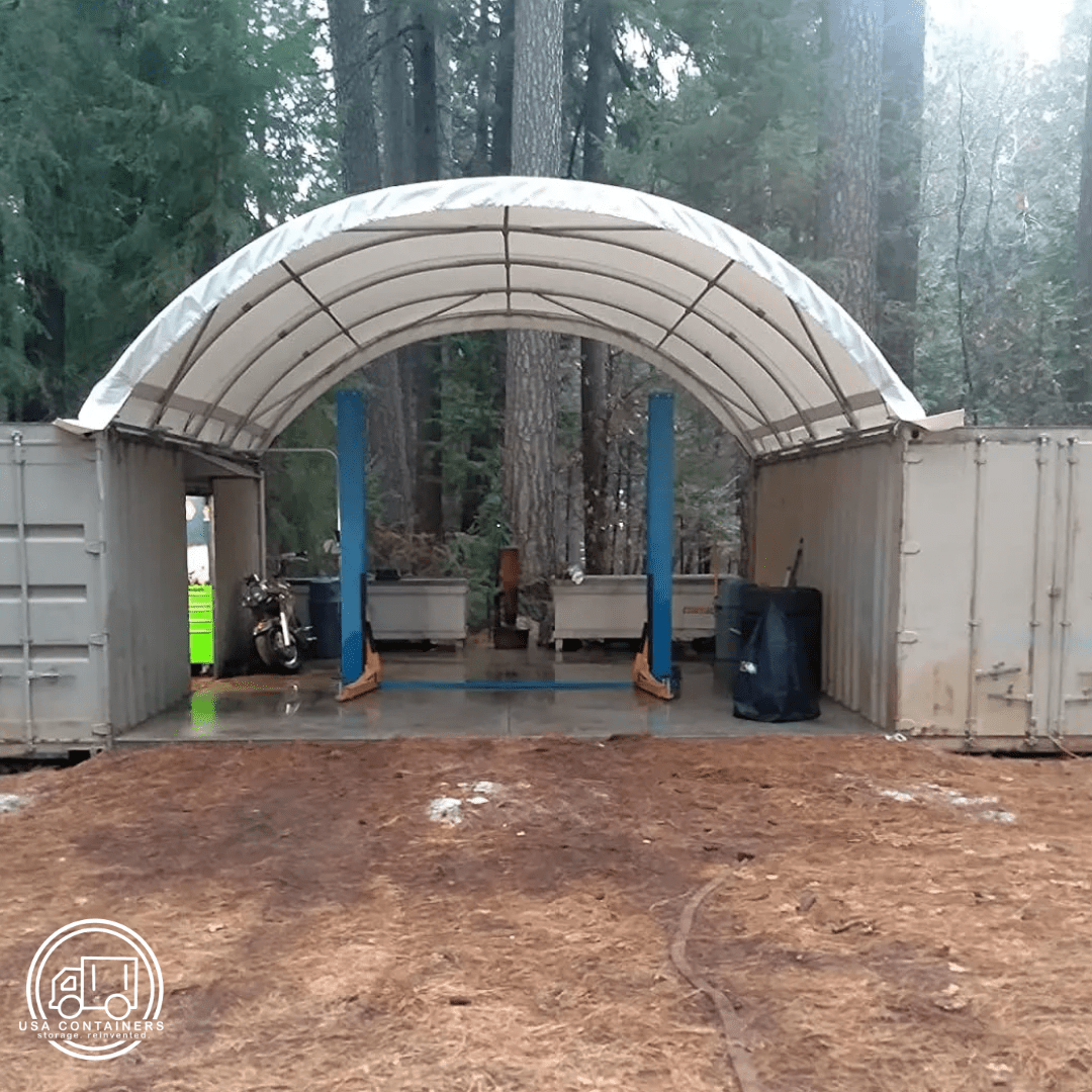 Heavy-duty white canopy roof shelter installed between two shipping containers for weather protection.