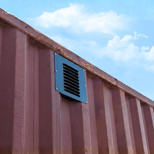 Powered wall vent mounted on the side of a shipping container