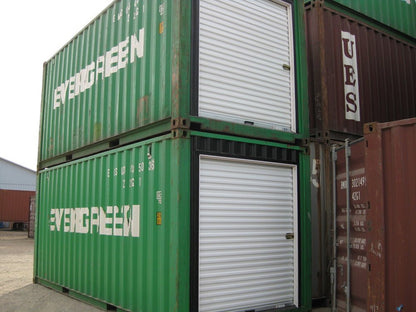 Green shipping containers with white roll up steel doors installed for easy access and secure storage usage